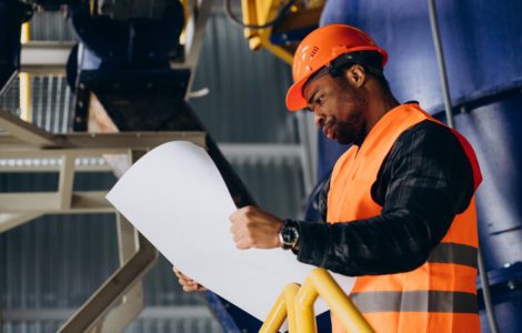 african-american-worker-standing-uniform-wearing-safety-hat-factory_1303-30612